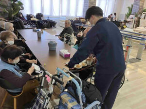 デイケアリハビリセンター前之浜で高校生1日体験学習として利用者との交流やおやつ配膳を体験している様子