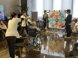 デイケアリハビリセンター前之浜で利用者と一緒にルーレットゲームを楽しむレクリエーションの様子