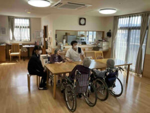 鹿児島商業高校の生徒が特別養護老人ホームたにやまの里で利用者様と交流する体験学習の様子