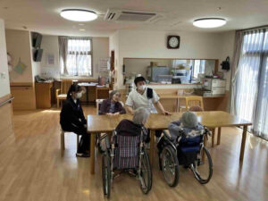 鹿児島商業高校の生徒が特別養護老人ホームたにやまの里で利用者様と会話をしながら交流する体験学習