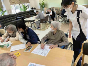 鹿児島市の住宅型有料老人ホームニコニコハウスで利用者様が落ち着いた空間の中で塗り絵に取り組んでいる日中活動の様子