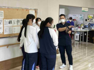 タブレット端末を使用しAIやIoTを活用した介護について高校生に説明している様子