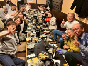 幅広い年代の医療・介護スタッフが笑顔で交流する親睦会の集合写真