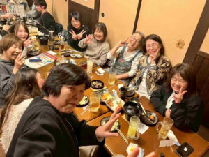 女性看護師やスタッフが食事を囲みながら笑顔で会話する親睦会の様子