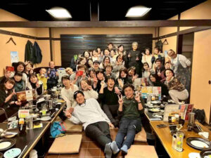 看護師・医療スタッフが集まり笑顔で写る親睦会の集合写真（職場の一体感）