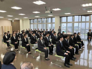 入社式に参加する新入職員が着席し話を聞く様子