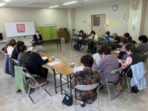 谷山福祉館で開催された南北西麓ふれあい会食にて在宅介護サービスの説明を受ける地域住民の様子