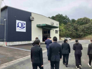 株式会社九飛勢螺にて製造工程の説明を受けながら工場見学を行う新入職員の様子