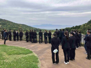 グリーンファーム内の展望スペースから喜入地域を一望する新入職員の様子