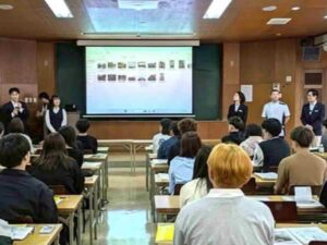 スクリーンに資料を映しながら、ICTや福祉現場の変化について説明するスタッフと真剣に話を聞く学生たち