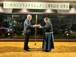 きいれセントラルクリニック10周年記念祝賀会で、ステージ上にて記念品を贈呈している様子