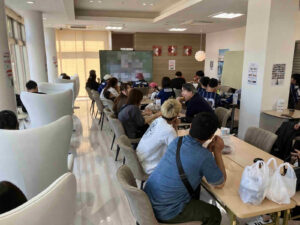 第3回ゆな愛ご褒美マルシェで、来場者が飲食を楽しみながらパブリックビューイングを観覧する様子