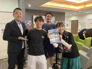 第3回ゆな愛ご褒美マルシェの会場で、ゲストと関係者が笑顔で記念撮影を行う様子