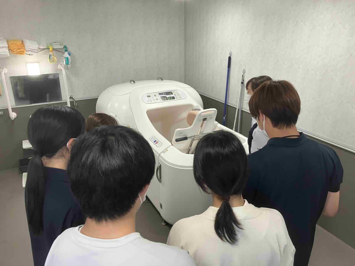 特別養護老人ホームうすきの里で、学生が介護機器や施設設備を見学している様子