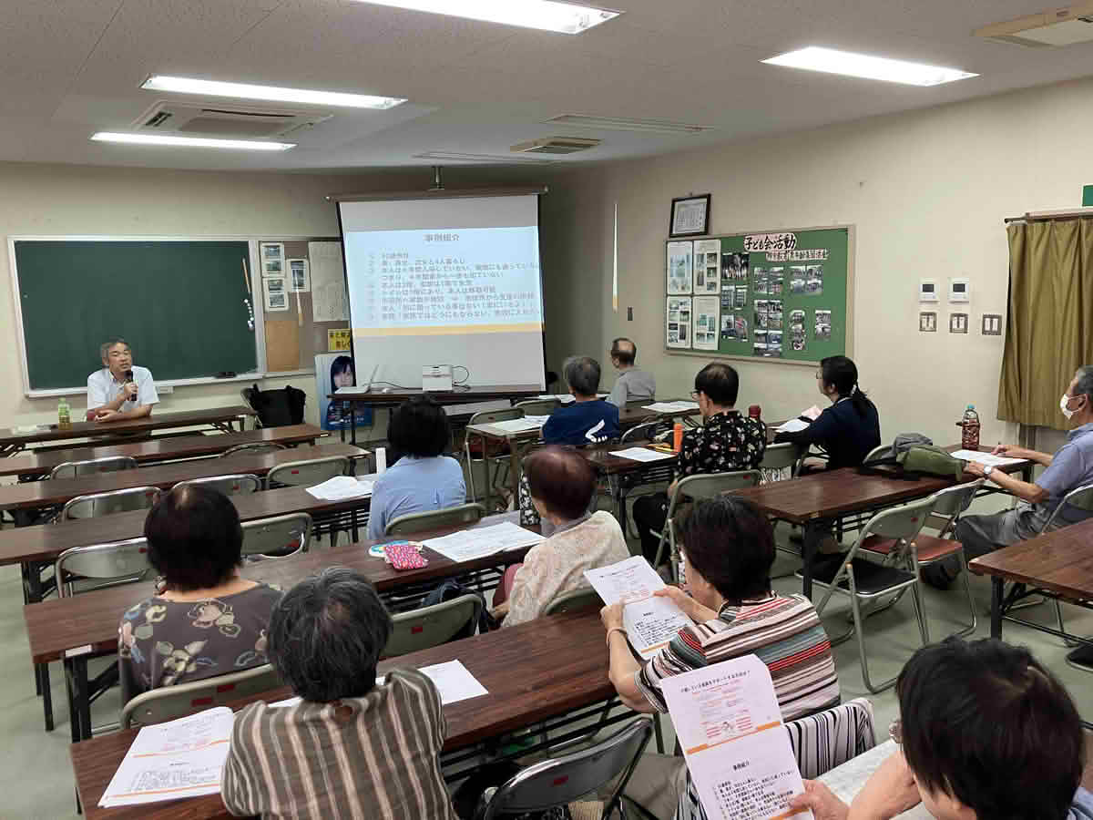 西谷山成人学級の出張福祉講座に参加し、資料を見ながら説明を聞く地域の皆さま