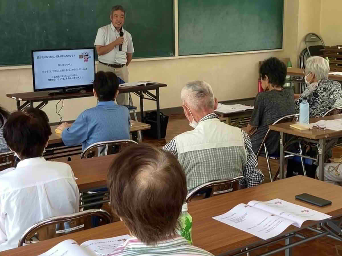 皇徳寺にこにこお達者クラブで、資料を見ながら認知症について学ぶ参加者の様子