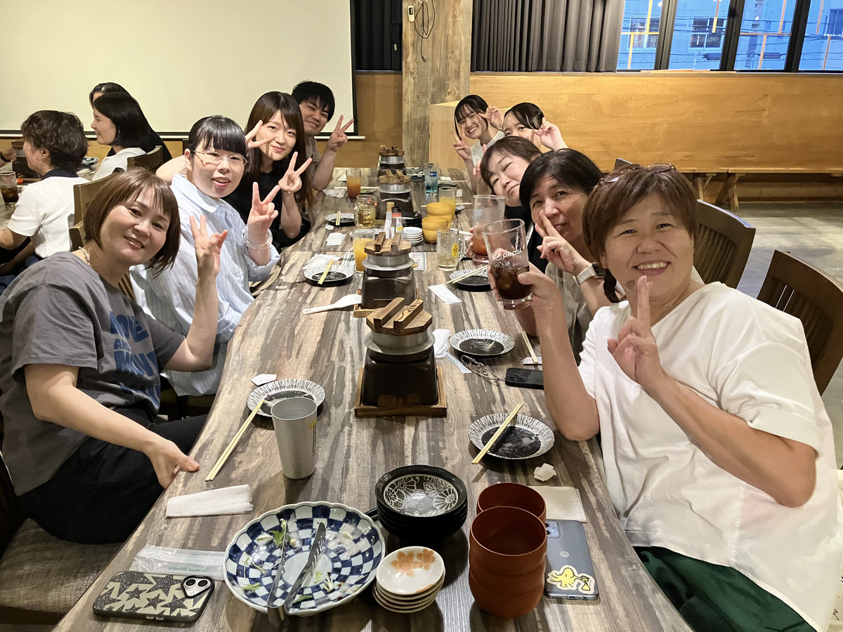 医療事業部の歓迎会・親睦会で、テーブルを囲み笑顔で交流する職員の様子