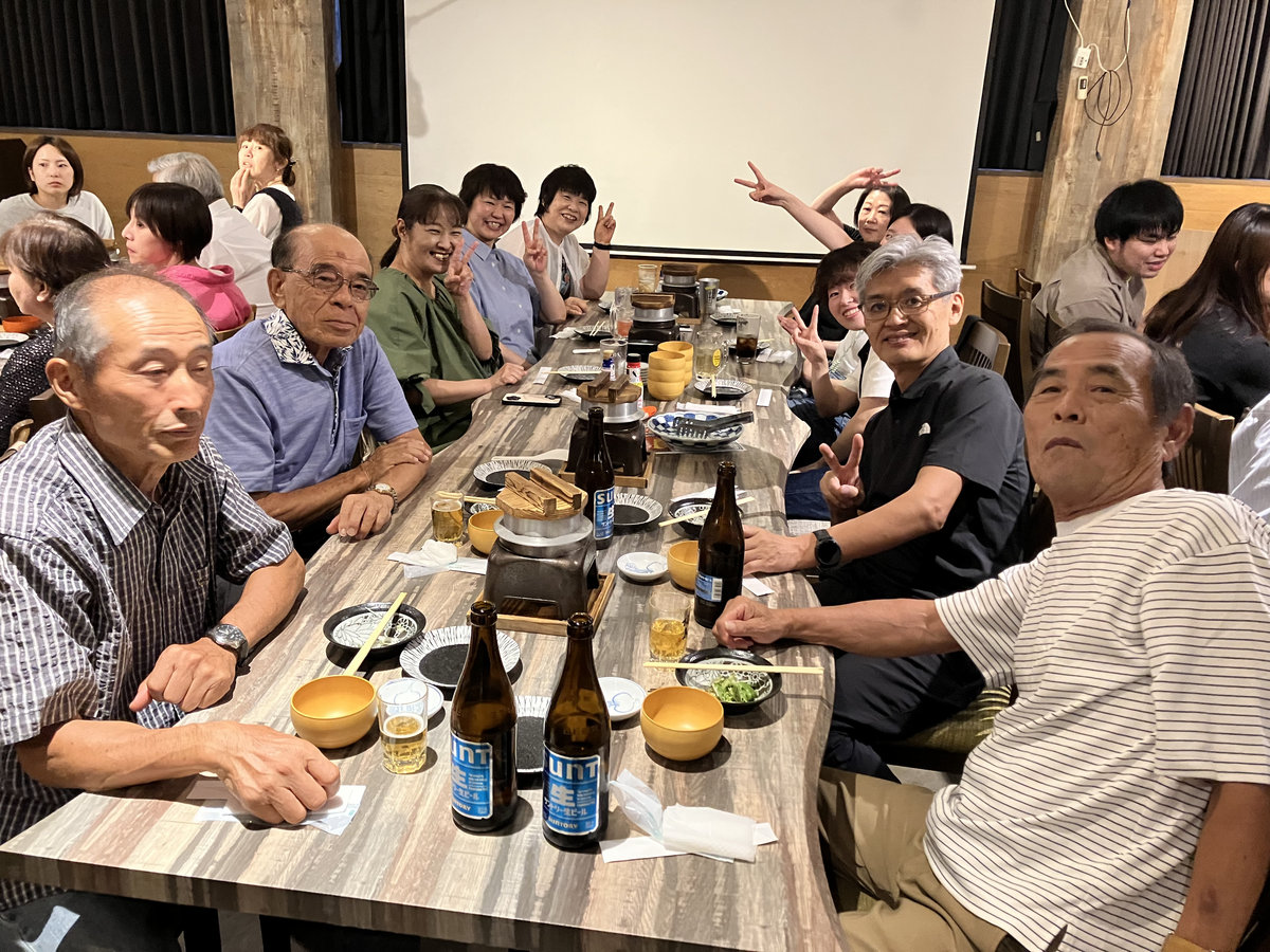 新入職員歓迎会・親睦会で、テーブルを囲み笑顔を見せる幅広い世代の職員