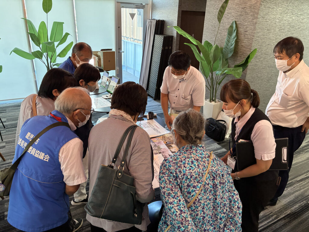 うすきの里の職員を囲み、資料を見ながら説明を聞く喜入民児協の参加者。
