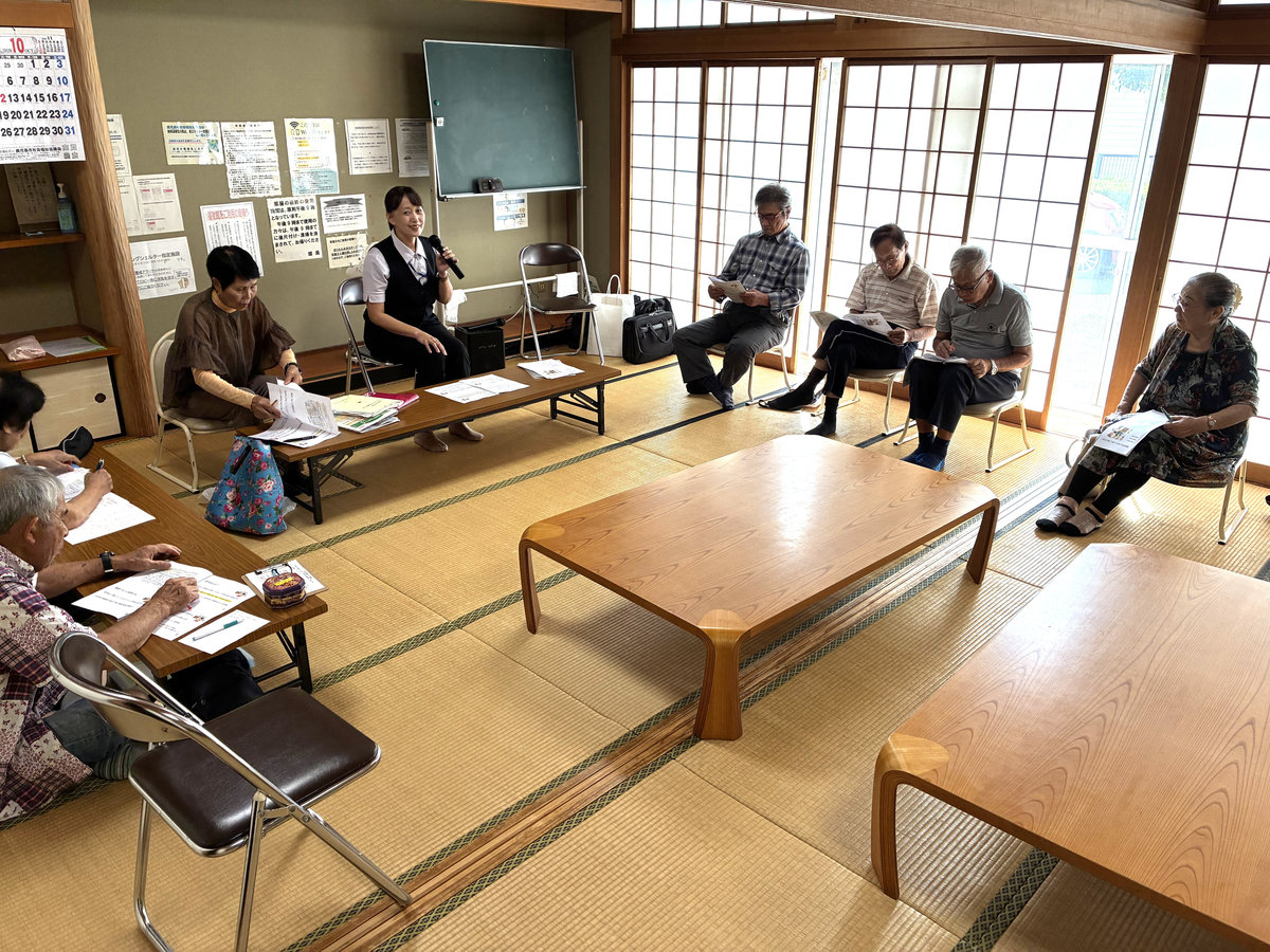 向原お達者クラブの参加者が、配布資料を見ながら認知症についての講義を聞く様子